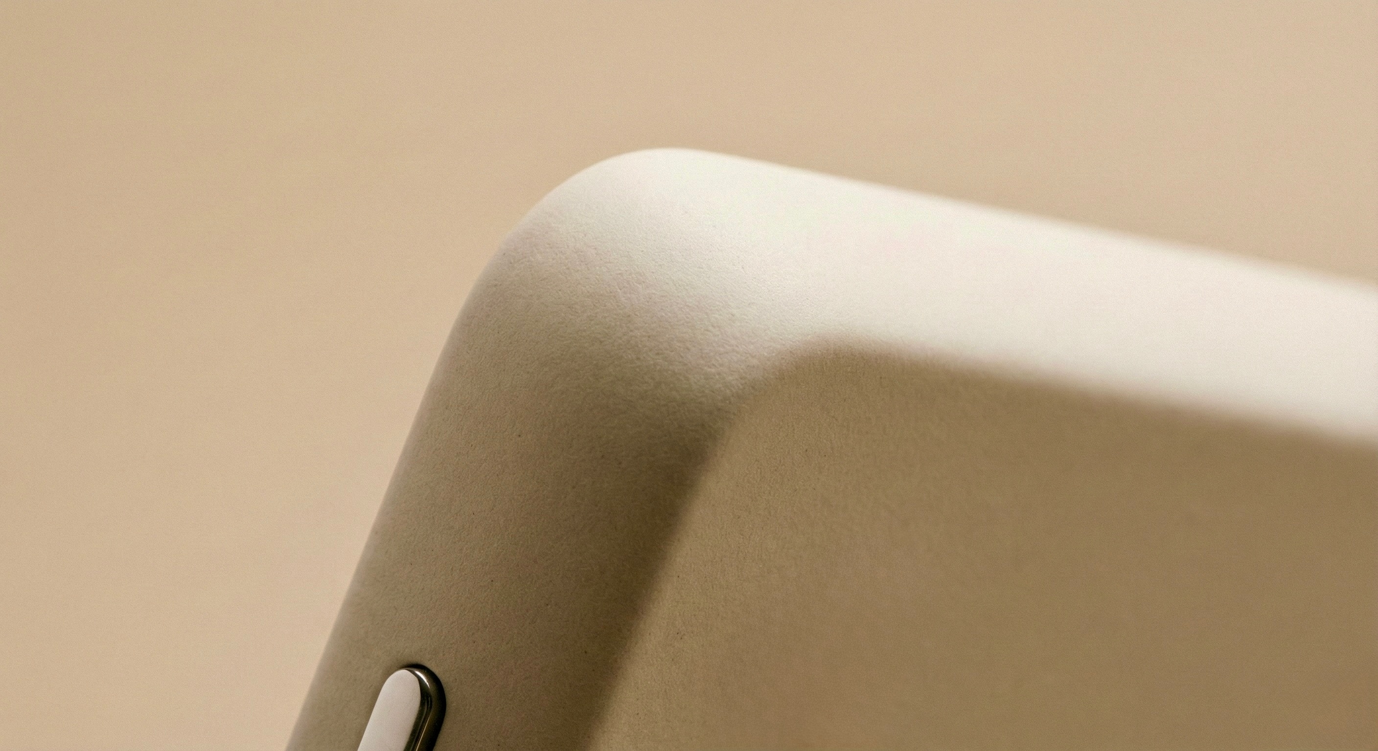Close-up of a curved corner of a sleek, modern device with a smooth dark surface.