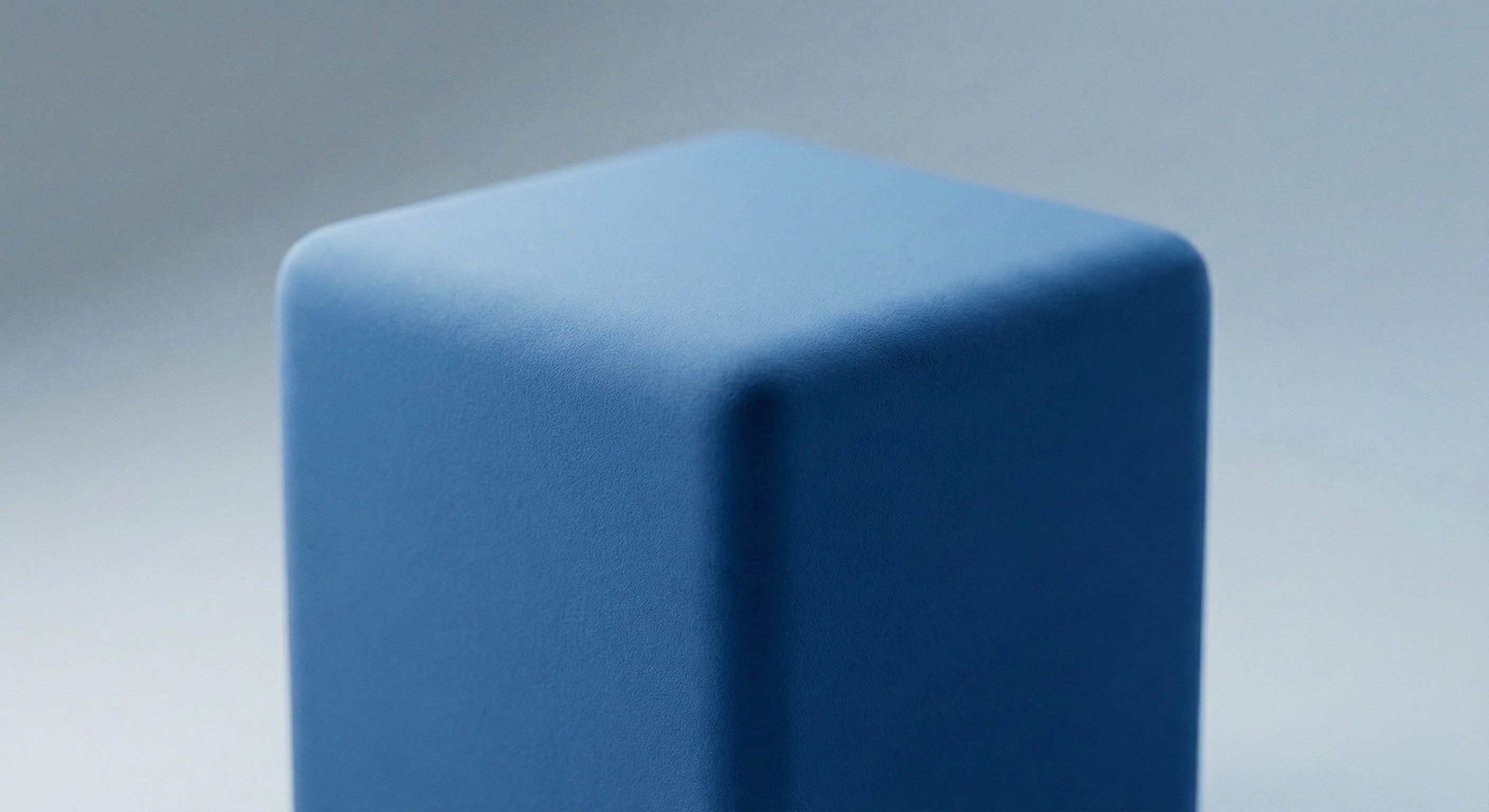 Close-up view of a rounded corner of a textured, dark gray-blue rectangular object against a matching background.